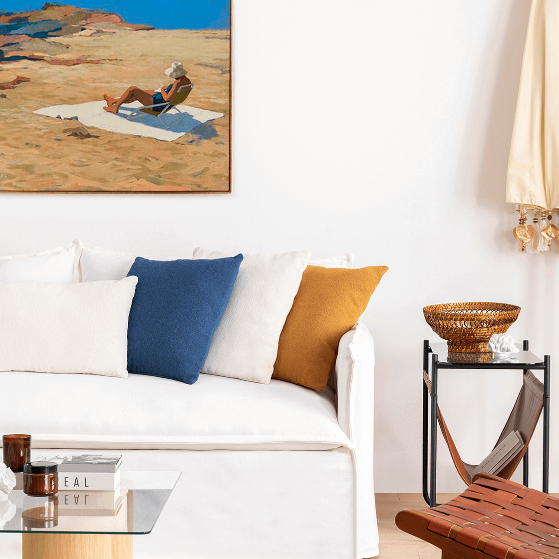 Beyaz kanepeli bir oturma odası ve duvarda bir kumsal resim